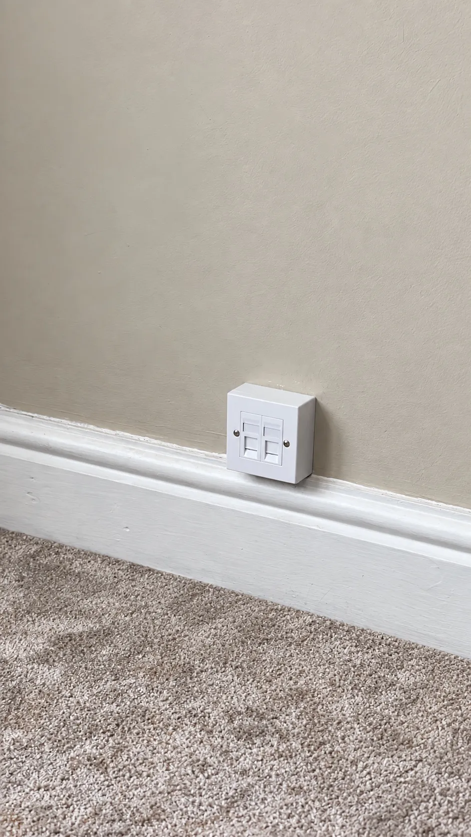 A small white network socket fitted just above the skirting board
